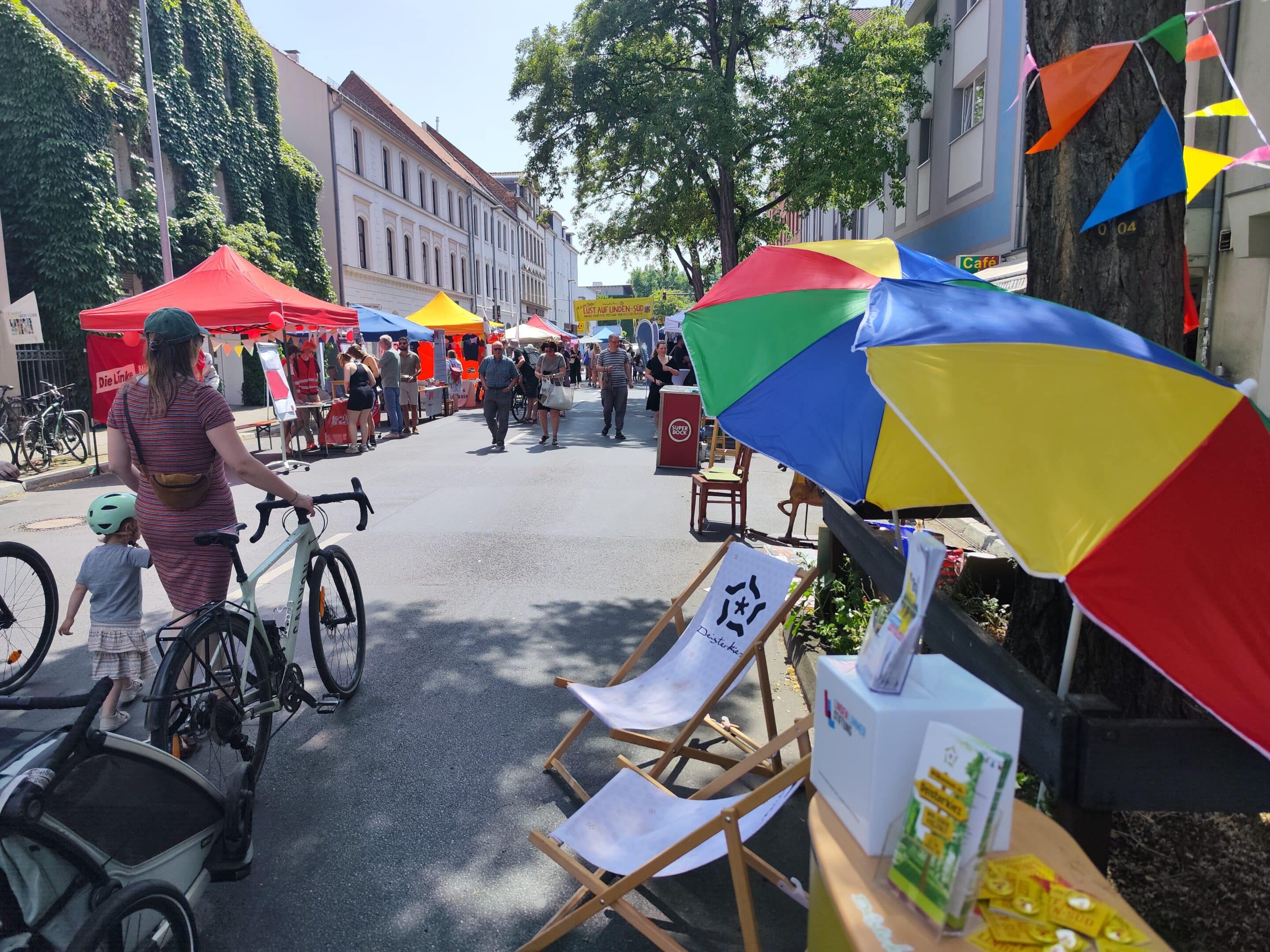 1750070260371 Menschen schlendern über die autofreie Deisterstraße beim Stadtteilfest Lust auf Linden-Süd 2026 mit bunten Zelten, Fahrrädern, Ständen und Musik.